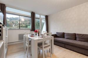 ein Wohnzimmer mit Tisch und Stühlen und einer Couch in der Unterkunft Kamélia - 10min des pistes in Xonrupt-Longemer