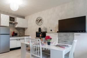 eine Küche mit einem weißen Tisch und weißen Stühlen in der Unterkunft Kamélia - 10min des pistes in Xonrupt-Longemer