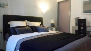 een slaapkamer met een groot bed met blauwe en witte kussens bij Villa Zaphira in La Hume