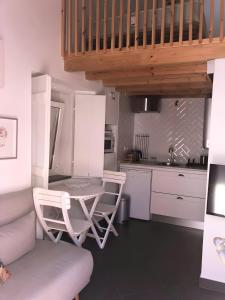 a kitchen with a table and chairs and a sink at Casa Das Batatas in Odeceixe