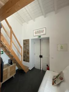 a bedroom with a bed and a staircase in a room at Casa Das Batatas in Odeceixe