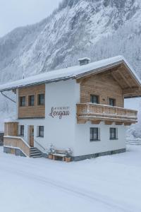a building with a sign on it in the snow at Alpenchalet Lengau in Dornauberg