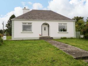 a white house with a lawn in front of it at Carrowreagh in Aclare