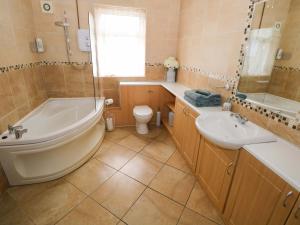 a bathroom with a tub and a toilet and a sink at Carrowreagh in Aclare +19 photos