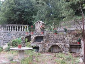 a stone wall with a table and a stone oven at Studio Églantine in Lorgues