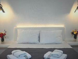een slaapkamer met een bed met twee handdoeken erop bij Super views in Mykonos in Panormos Mykonos +2 foto's