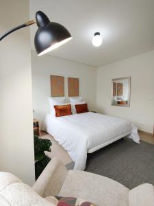 ein Schlafzimmer mit einem großen weißen Bett und einer Couch in der Unterkunft Douro Valley Private Terrace & Lounge in Armamar