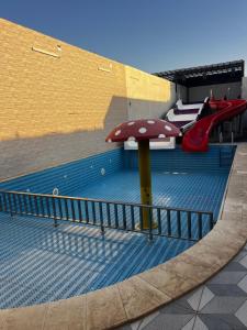 een zwembad met een speeltuin met parasol bij شاليهات ديم لايت in Az Zulfi