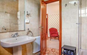 a bathroom with a sink and a red chair at Villa Rosa Luxury Singular in Padrón +17 photos