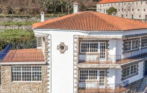 a white house with a red roof at Villa Rosa Luxury Singular in Padrón