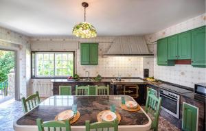 a kitchen with green cabinets and a table with chairs at Villa Rosa Luxury Singular in Padrón