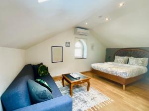 een slaapkamer met een bed en een blauwe bank bij Boreal Porto Gaia - Patio & Pool in Vila Nova de Gaia +50 foto's