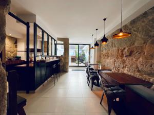 een restaurant met tafels en stoelen en een stenen muur bij Boreal Porto Gaia - Patio & Pool in Vila Nova de Gaia