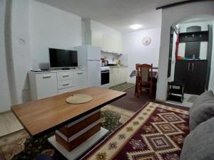 a living room with a table and a kitchen at Stan na dan Apartman Kozarac in Kozarac