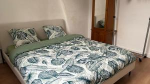 a bedroom with a bed with a blue and white comforter at T2 proche du CH d'Arras in Sainte-Catherine