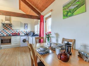 Una cocina y un comedor con una mesa de madera. en The Cartlinhay - Uk35756, en Bideford