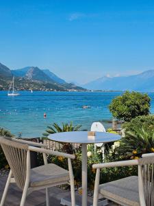 a table and chairs on a balcony with a view of the water at Puravida 4seasons - Nature Hideaway in Arveaco