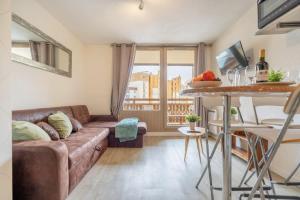 ein Wohnzimmer mit Sofa und Tisch in der Unterkunft Ski In-Out - Heart of Val Thorens Beautiful View, WiFi in Val Thorens