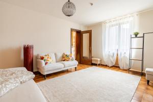 a white living room with a couch and a chair at Puravida 4seasons - Nature Hideaway in Arveaco