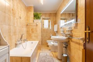 a bathroom with a sink and a tub and a toilet at Puravida 4seasons - Nature Hideaway in Arveaco