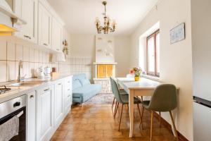 a kitchen with white cabinets and a table and chairs at Puravida 4seasons - Nature Hideaway in Arveaco