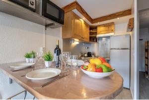 eine Küche mit einem Tisch mit einer Obstschale darauf in der Unterkunft Ski In-Out - Heart of Val Thorens Beautiful View, WiFi in Val Thorens