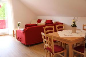 a living room with a red couch and a table at Haus Beilerstädtle in Oppenau