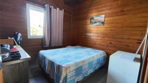 a small bedroom with a bed in a wooden room at Chalé do Alemão in Imbituba +16 photos