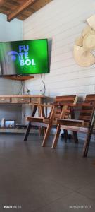 a flat screen tv sitting on top of a wooden picnic table at Chalé do Alemão in Imbituba