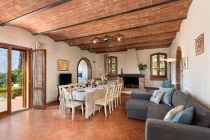 a living room with a table and chairs and a fireplace at Villa Aurea - Private Pool & Garden in Tuscany in Canneto