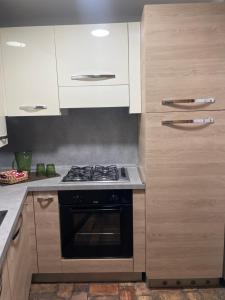 a kitchen with a stove and white cabinets at Ca' Dei Sassi in Sequsino