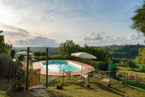 a swimming pool with two chairs and an umbrella at Villa Aurea - Private Pool & Garden in Tuscany in Canneto