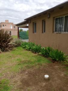 a house with a yard with plants in front of it at Casita Las Acequias in Roldán