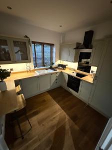 a kitchen with white cabinets and a wooden floor at Warmsworth Mews in Warmsworth +13 photos