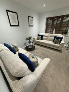 WarmsworthにあるWarmsworth Mewsのリビングルーム(白いソファ2台、青い枕付)