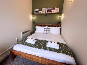 a bedroom with a bed with two towels on it at Pass the Keys Cosy Romantic Getaway with Hot Tub in Whithorn