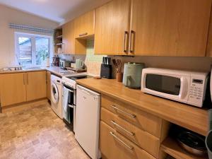 a kitchen with a counter with a microwave and appliances at Pass the Keys Cosy Romantic Getaway with Hot Tub in Whithorn