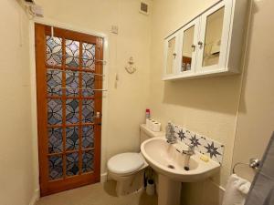 a small bathroom with a toilet and a sink at Pass the Keys Cosy Romantic Getaway with Hot Tub in Whithorn +21 photos
