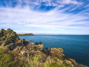 a view of the ocean from a rocky shore at Pass the Keys Cosy Romantic Getaway with Hot Tub in Whithorn