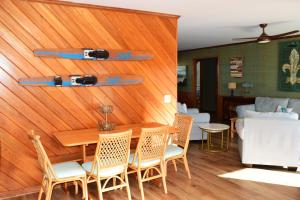 a dining room with a table and chairs and a couch at Keepin It Reel in Holden Beach