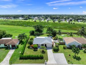 an aerial view of a house with a golf course at Lush - Tropical - Modern Home - Heated Pool and Spa in Port Saint Lucie
