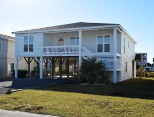 a large white house with a large porch at Keepin It Reel in Holden Beach