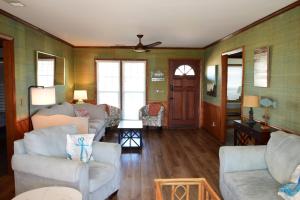 a living room with two couches and a table at Keepin it Reel in Holden Beach