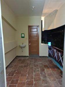 a hallway with a door and a sink at Daya Dharmam Residency in Tiruvannāmalai +19 photos