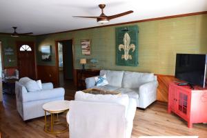a living room with white furniture and a flat screen tv at Keepin It Reel in Holden Beach