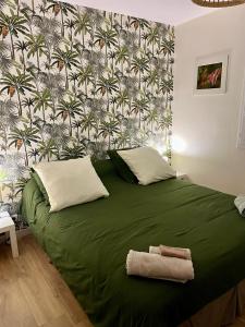 a green bed with two towels on top of it at l’Anita in Théoule-sur-Mer