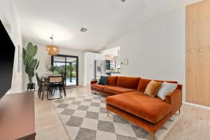 a living room with a couch and a table at Lush - Tropical - Modern Home - Heated Pool and Spa in Port Saint Lucie +35 photos