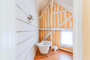 ein Badezimmer mit weißer Badewanne und Fenster in der Unterkunft L'Esprit Loft - Logement atypique pour 12 pers in Honfleur + 41 Fotos