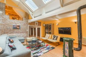 ein Wohnzimmer mit grauem Sofa und einer Backsteinwand in der Unterkunft L'Esprit Loft - Logement atypique pour 12 pers in Honfleur