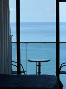 une pièce avec une table et une vue sur l'océan dans l'établissement NBG Apartments, à Batoumi